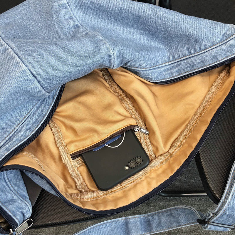 Denim sling bag interior with zip pocket and double zipper closure