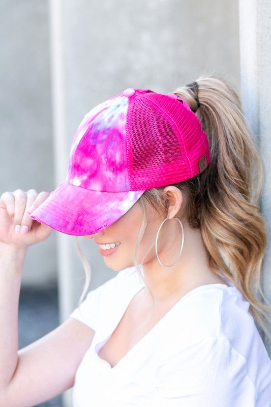 Hot pink tie dye criss cross ponytail cap worn angled front view