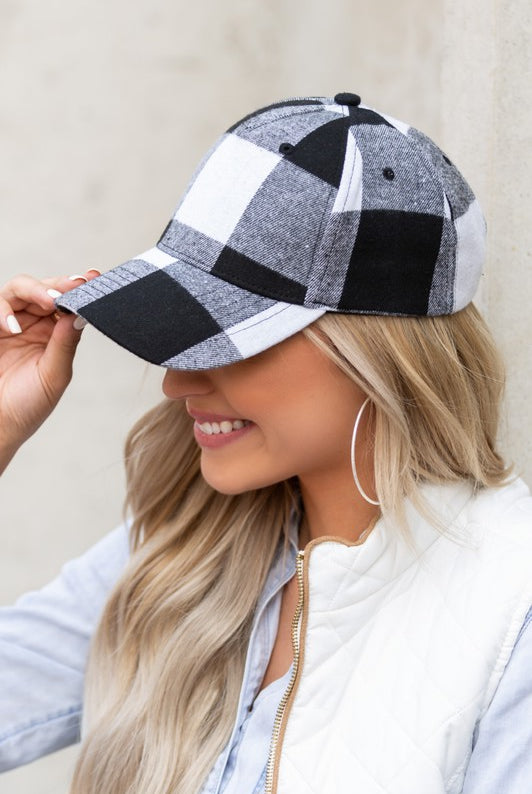 Close-up of white and black buffalo plaid knit flannel baseball hat with curved brim.