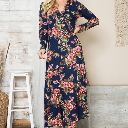 AVAH-Front view of woman wearing navy floral wrap maxi dress, standing in front of neutral background