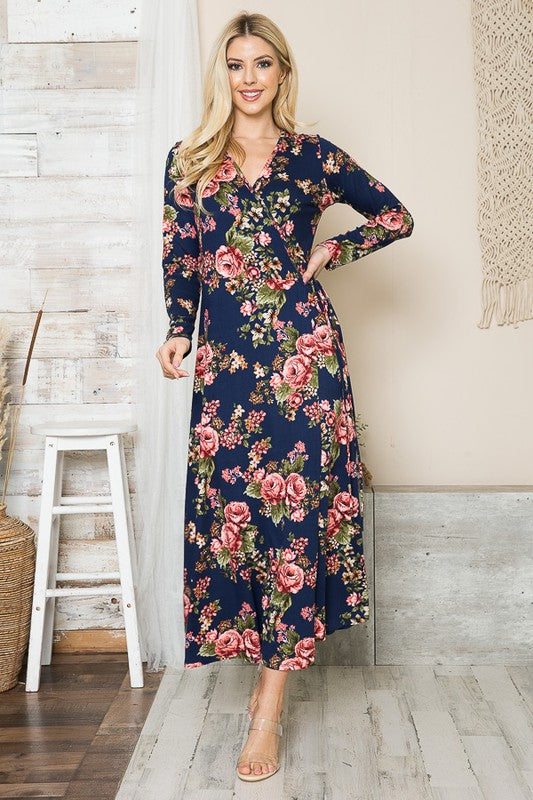 AVAH-Front view of woman wearing navy floral wrap maxi dress, standing in front of neutral background