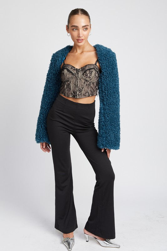 Full body view of cropped shrug styled with lace top and flared pants