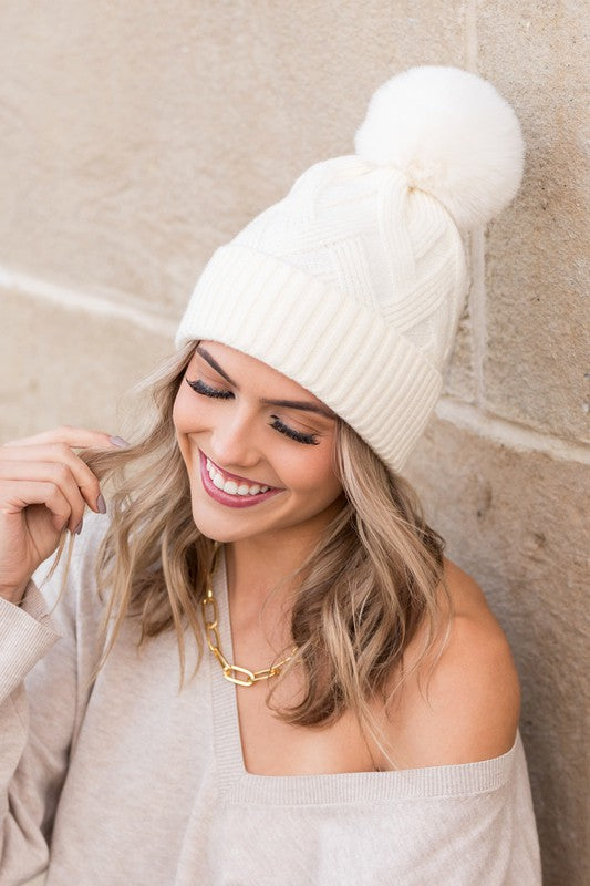White knit winter hat with faux fur pom, front view