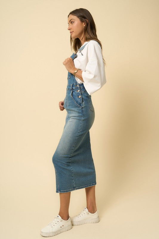 Side view of fitted denim midi overall showing button closure and pockets