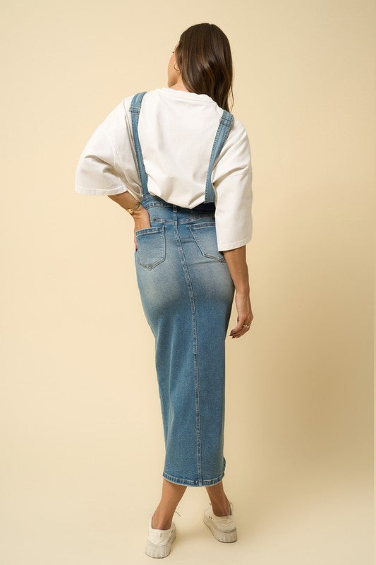 Back view of denim overall midi dress with straps and back pockets