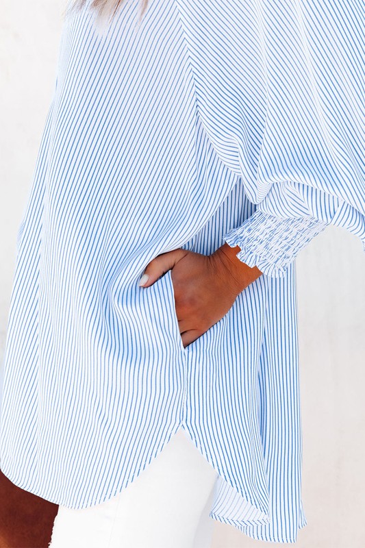Side detail of blouse showing hidden pocket and smocked sleeve cuff