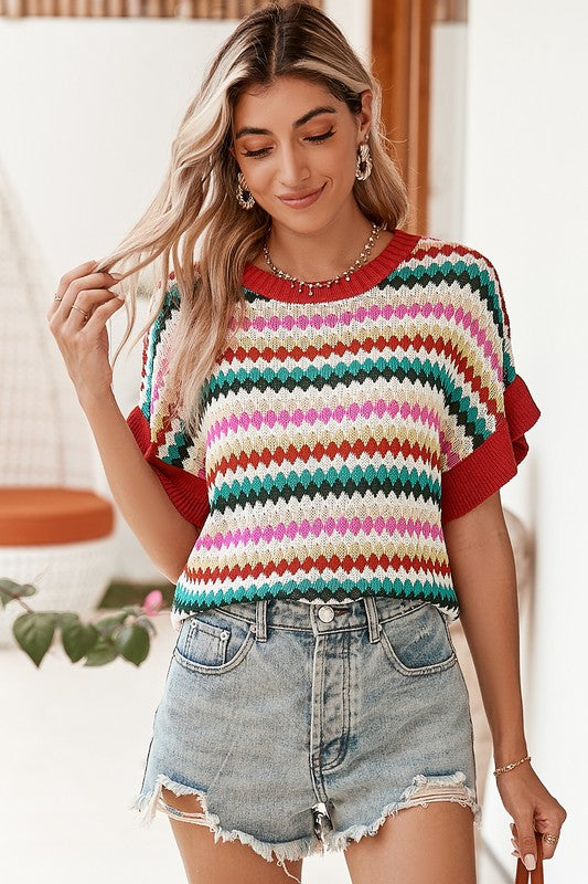 Close-up front view of colorful chevron knit top paired with denim shorts