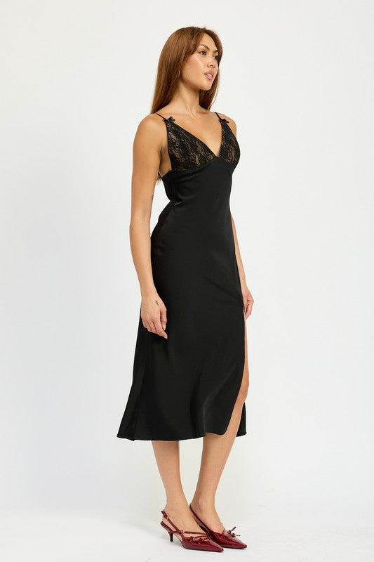 Side view of black satin slip midi dress featuring a thigh-high side slit.