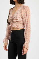 Side view of blush plaid ruched crop blouse with adjustable drawstring and ruffled hem.