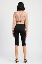 Back view of blush plaid ruched blouse with ruffled cuffs and cropped hemline.