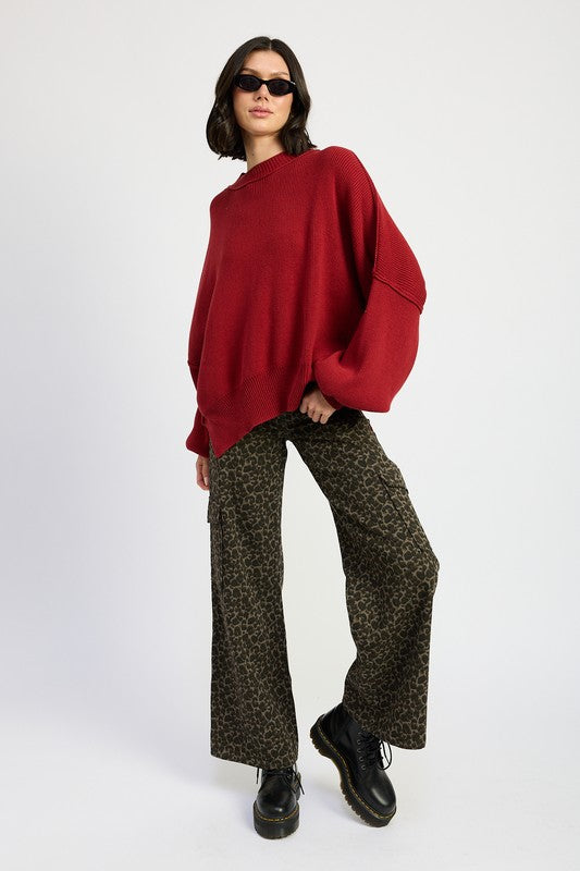 A model wearing red long-sleeve top and leopard print mid-rise wide-leg cargo pants