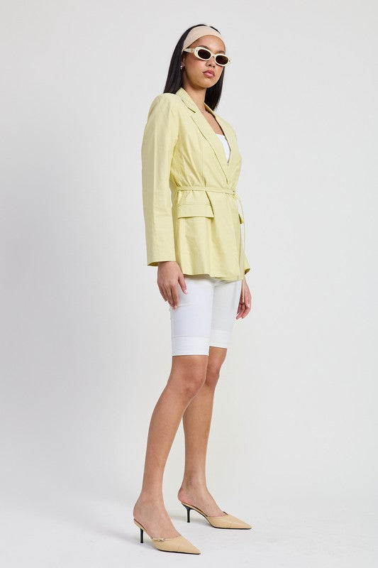 Side angle of sage tailored blazer showing cinched silhouette and modern fit