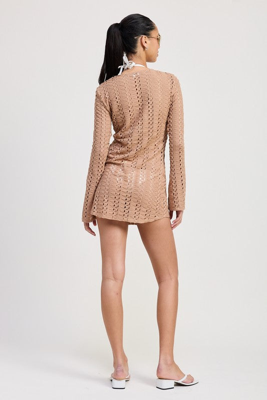 Back view of model wearing tan crochet beach cover-up with long sleeves and mini hemline