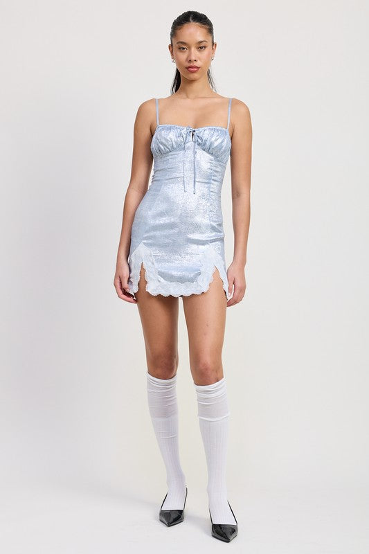Model standing full-length in metallic blue slip dress with knee-high socks and heels