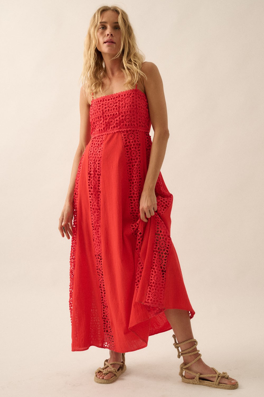 Model wearing red cotton eyelet lace dress paired with woven rope sandals, showcasing side lace paneling