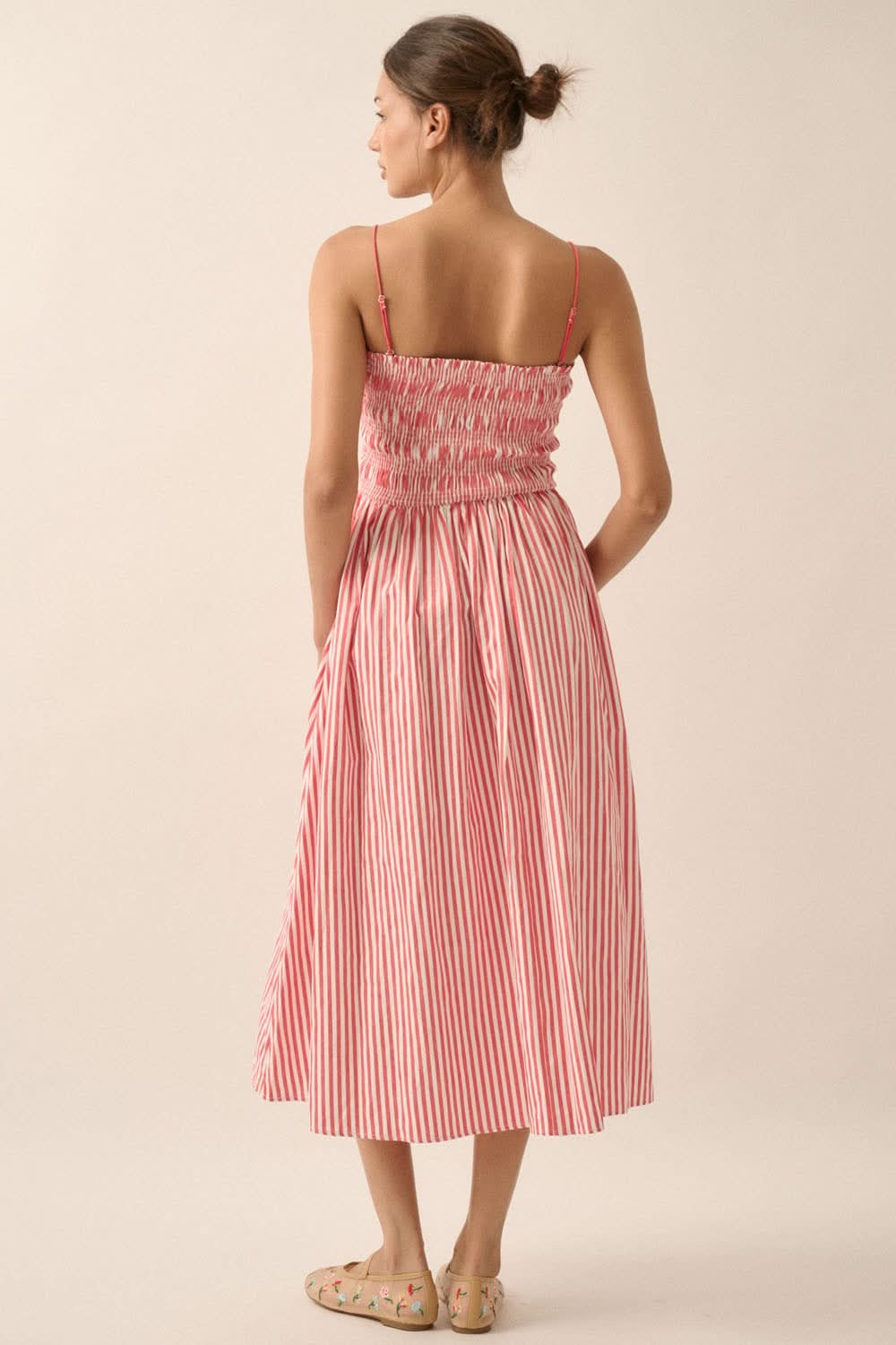 Back view of red striped dress with low back, smocked bodice, and adjustable straps