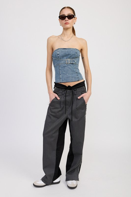 Full body shot of model in denim strapless top styled with drawstring trousers and sneakers