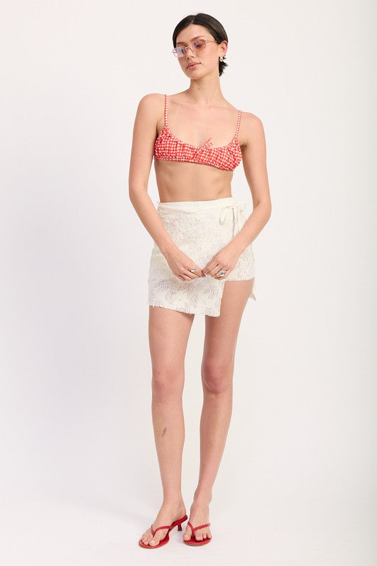 Full front view of lace mini skirt styled with red check bikini top