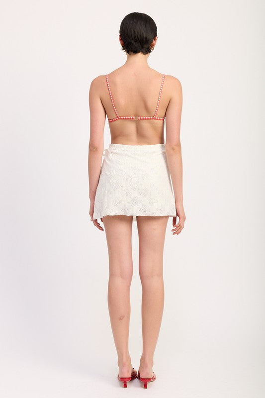 Back view of floral lace skirt styled with swim top and red heels
