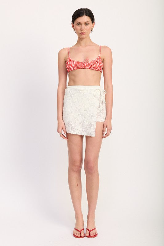 Full front view of lace mini skirt styled with red check bikini top