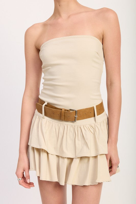 Close-up of strapless neckline and brown belt on beige ruffle mini dress
