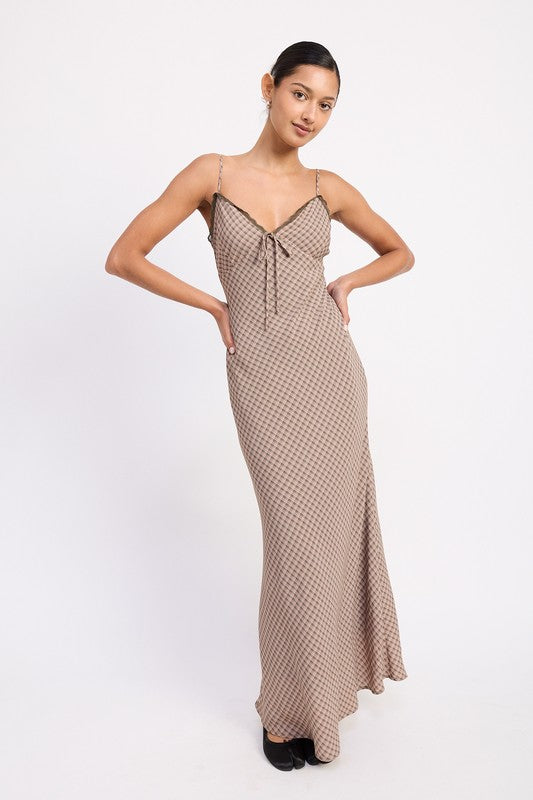 Model wearing lattice print maxi dress with lace trim neckline and tie detail, front view