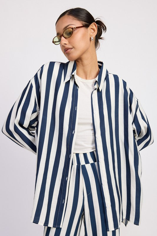 AVAH-Model wearing oversized navy and white vertical striped shirt open over a white tank