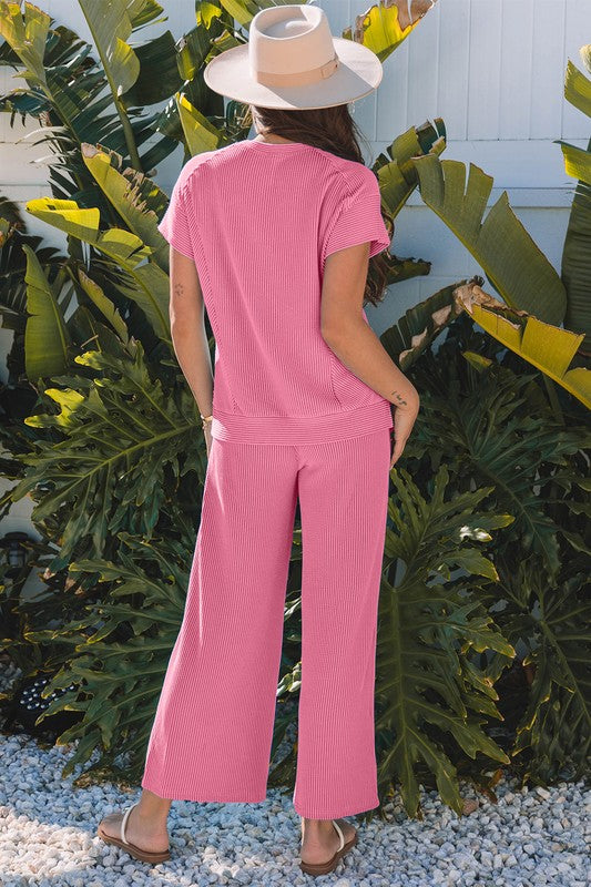 Back view of pink two-piece knit set, showing corded fabric detail.