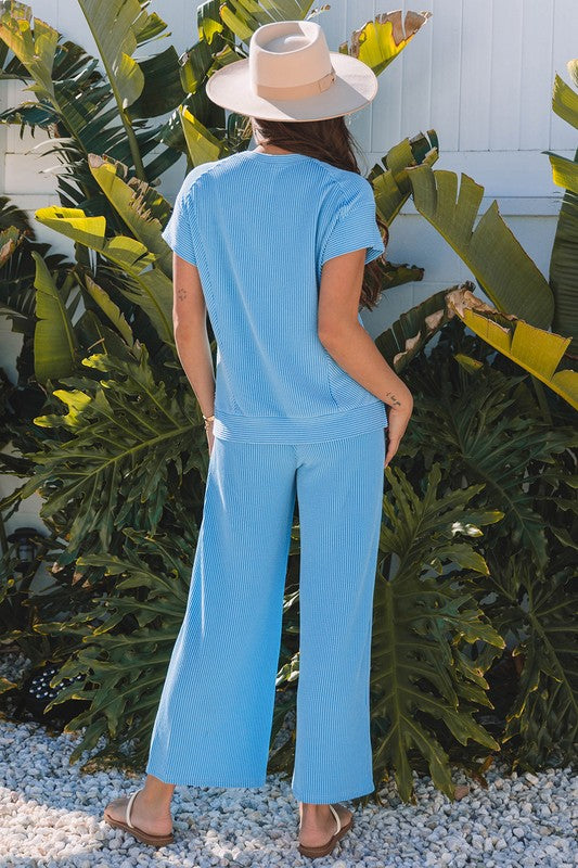 Back view of blue knit lounge set styled with flip-flops.