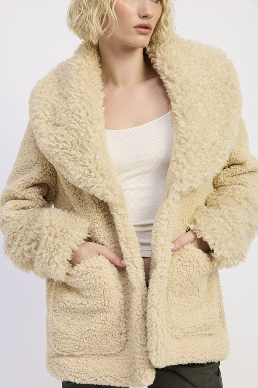 Close-up of beige taupe sherpa teddy coat with oversized collar and pockets