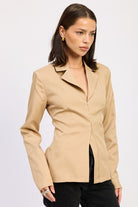 Side view of camel fitted blazer showing structured seams and waist shape.