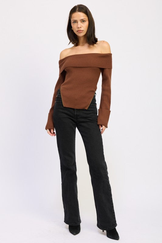 Model in brown off the shoulder ribbed sweater with foldover neckline, styled with black denim and boots.