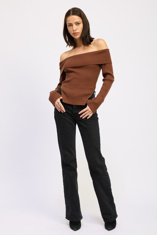 Brown off the shoulder ribbed sweater with foldover neckline and wide cuffs, standing pose