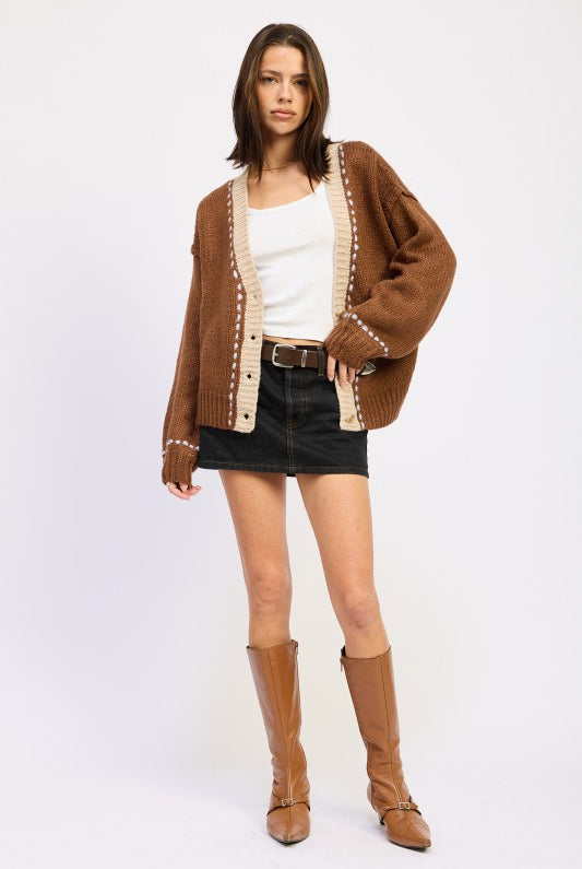 Full outfit with brown cardigan, black denim mini skirt, and tan boots.