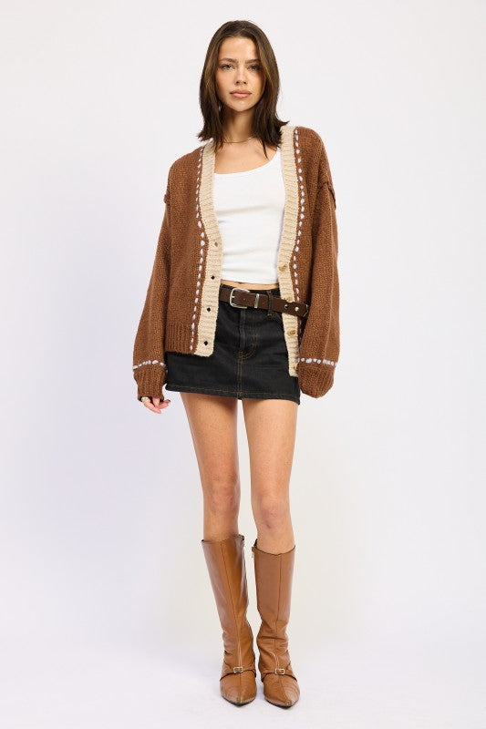 Full outfit with brown cardigan, black denim mini skirt, and tan boots.