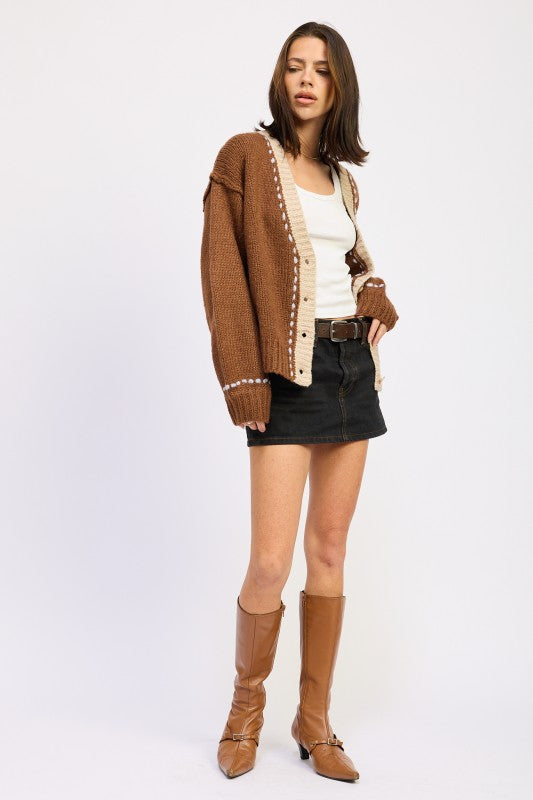 Full outfit with brown cardigan, black denim mini skirt, and tan boots.
