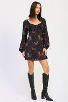 angled view of fall floral mini dress paired with black boots