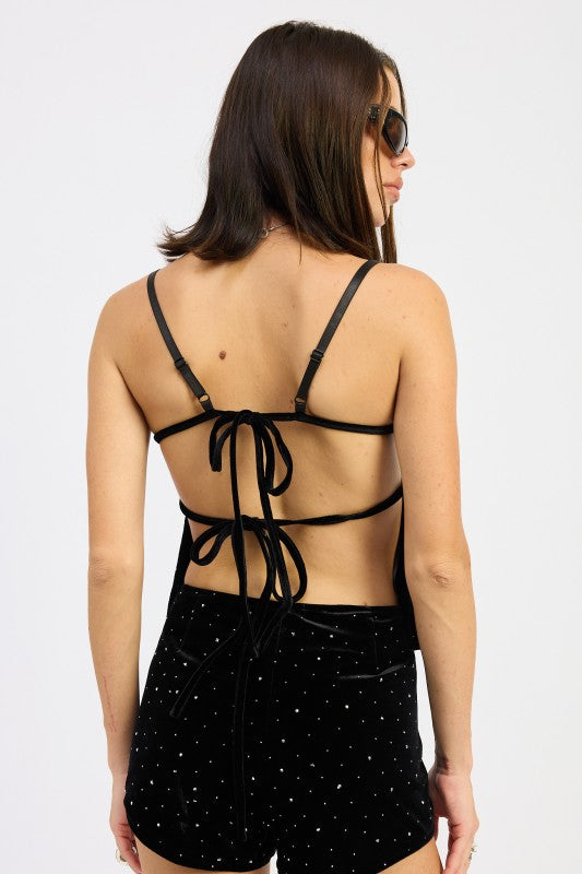 Back view of black velvet rhinestone cami top featuring open back and double tie closures.