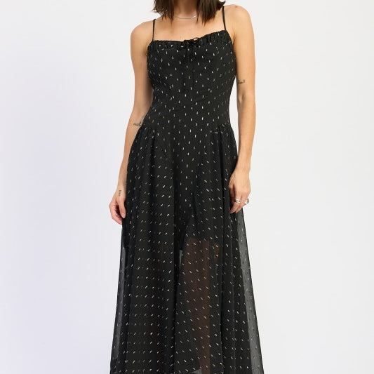 Model wearing a black spaghetti strap maxi dress with ruched neckline and dotted texture, styled with silver heels against a light backdrop-AVAH
