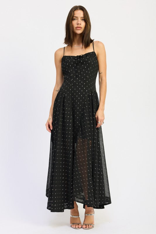 Model wearing a black spaghetti strap maxi dress with ruched neckline and dotted texture, styled with silver heels against a light backdrop-AVAH
