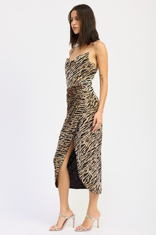Side angle of zebra print midi dress highlighting curve-skimming fit, draped neckline, and wrap-style slit-AVAH