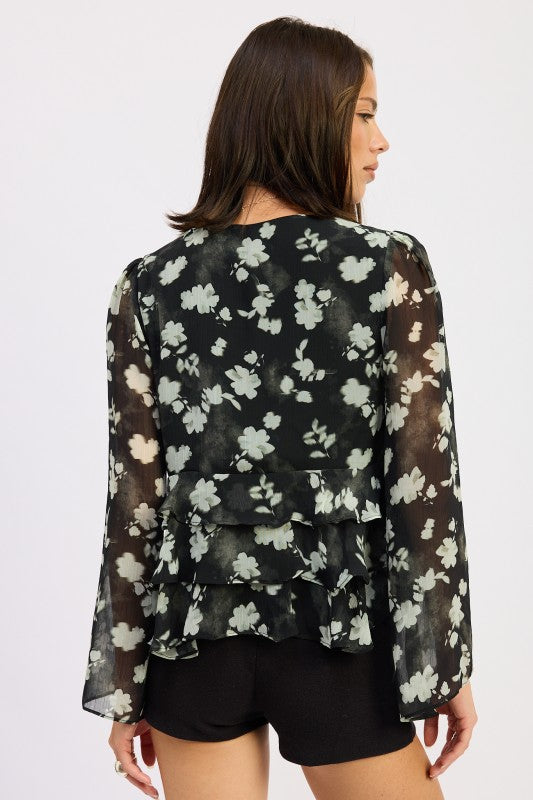Back view of sheer floral peplum top with tiered ruffles.