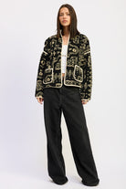 Full-body view showing sherpa jacket styled with black wide-leg pants.