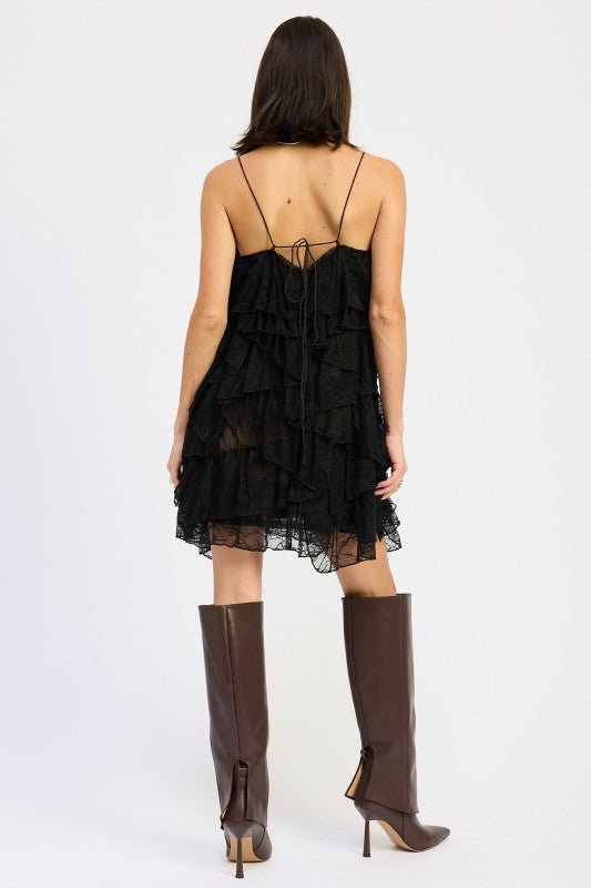 Back view showing tie-back detail and layered lace ruffles on mini dress.