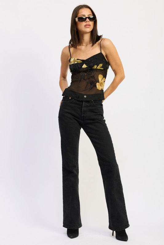model wearing black and gold floral cami with sunglasses and black pants