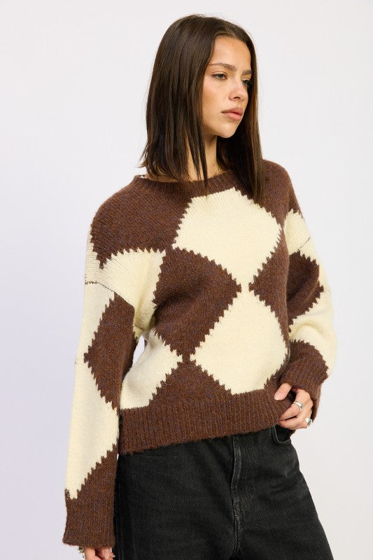 Brown and cream argyle knit sweater with dropped shoulders and ribbed hem, paired with black jeans for a laid-back outfit.-AVAH