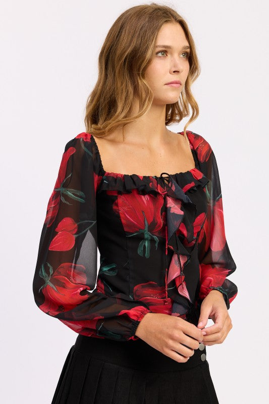 Side view of sheer floral blouse with ruffle trim and square neckline.