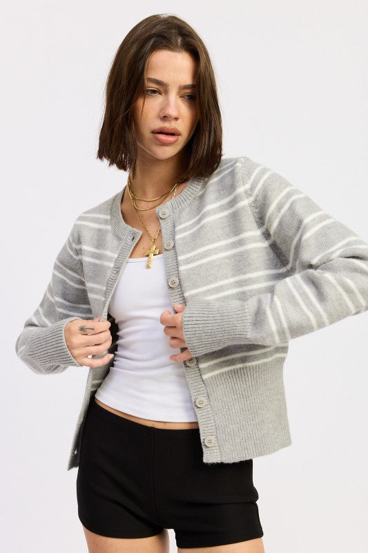 Model wearing grey and white striped button cardigan with white tank underneath – front view