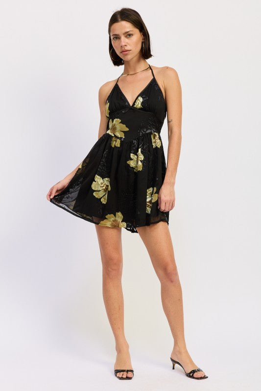 Full-length view of black floral halter mini dress with flowy skirt
