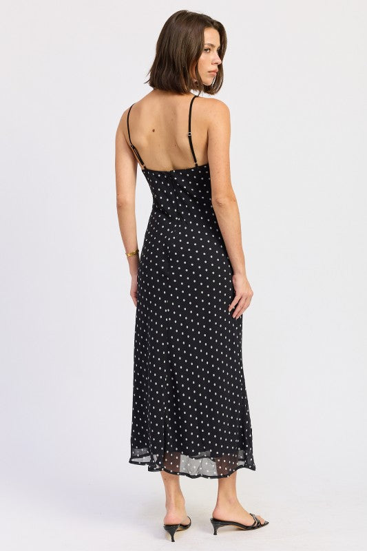 Back view of black polka dot midi slip dress with thin straps and zip closure.